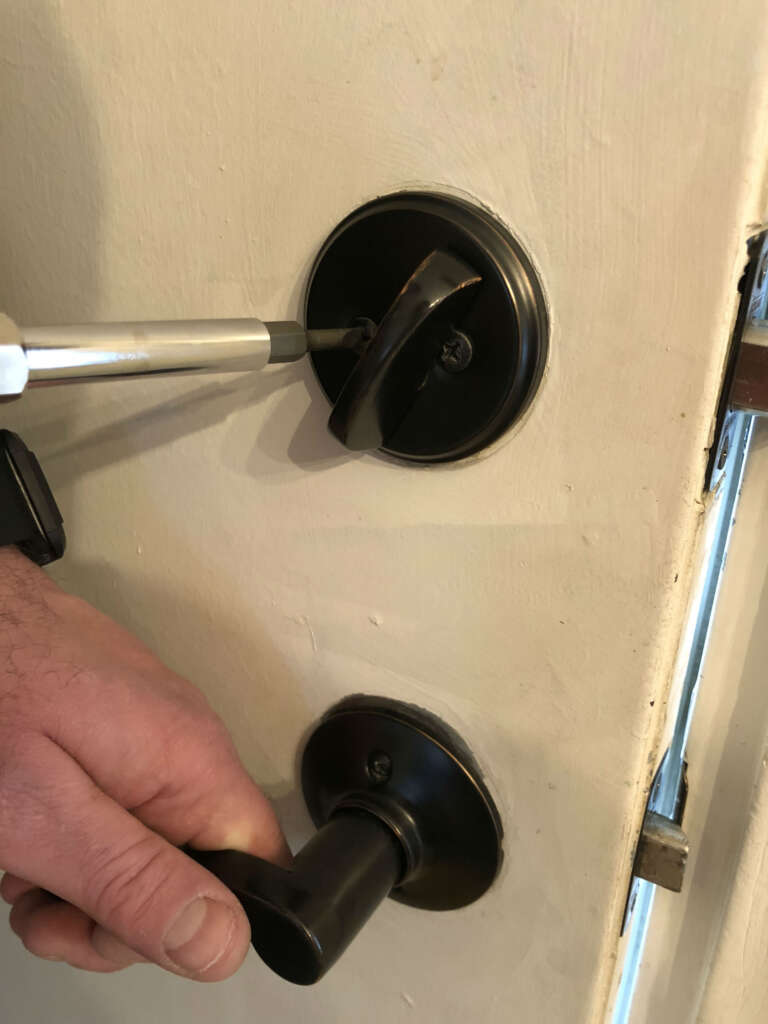Locksmith replacing the lock on the home door